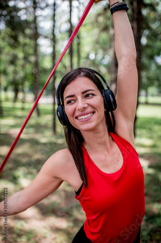 Woman exercising with elastic band outdoors 