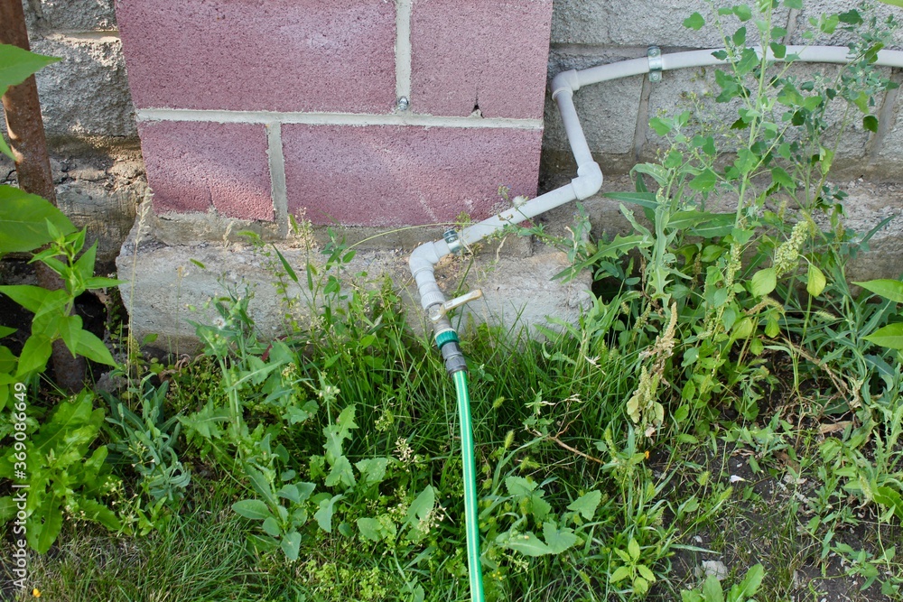 Watering hose stretched along the fence Watering hose stretched along the fence