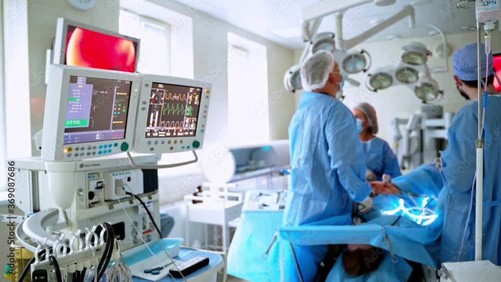 Medical procedure in operating theater. Specialists use modern medical equipment during surgery on a patient. Health workers take care of a patient. Medical procedure in operating theater. Specialists use modern medical equipment during surgery on a patient. Health workers take care of a patient.