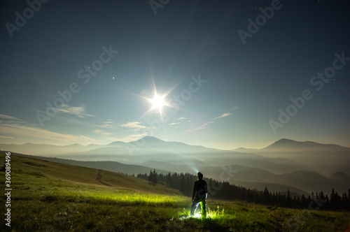 Silhouette of a man on a moonlit night in the carpathian mountains