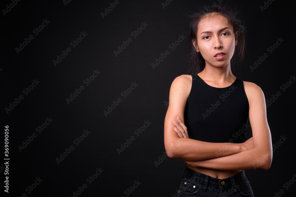 Young beautiful Asian transgender woman against black background Young beautiful Asian transgender woman against black background