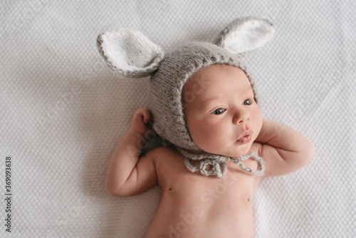 Curious newborn in funny knitted bonnet photo