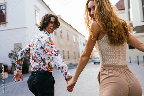 Cheerful young couple and laughing together walking away