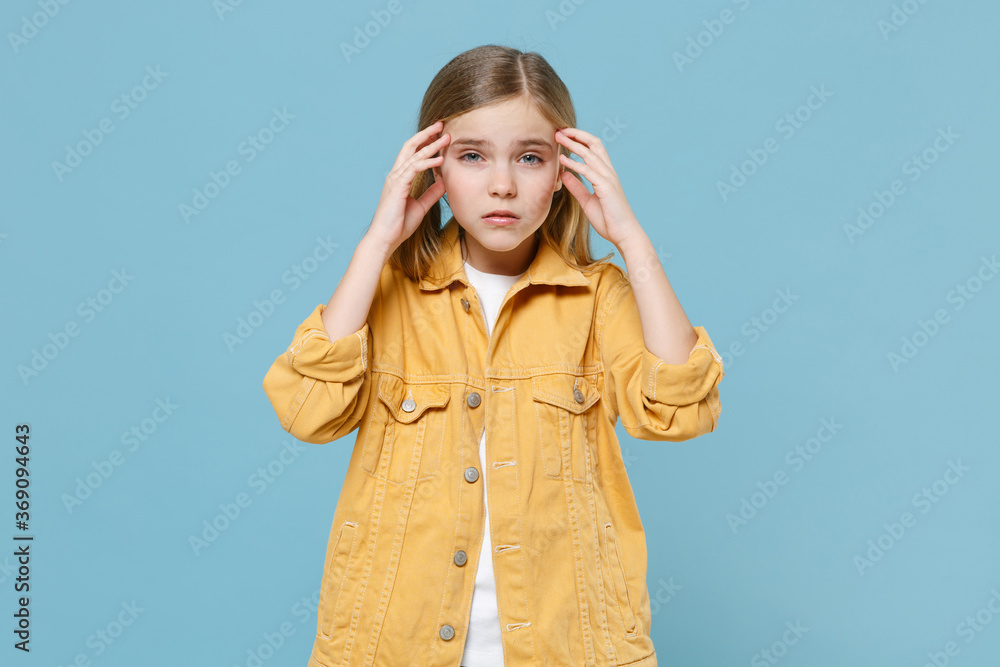 Tired concerned little blonde kid girl 12-13 years old in yellow jacket isolated on pastel blue background children studio portrait. Childhood lifestyle concept. Mock up copy space. Put hands on head. Tired concerned little blonde kid girl 12-13 years old in yellow jacket isolated on pastel blue background children studio portrait. Childhood lifestyle concept. Mock up copy space. Put hands on head.