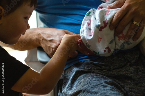 Toddler discovers his newborn siblings foot photo