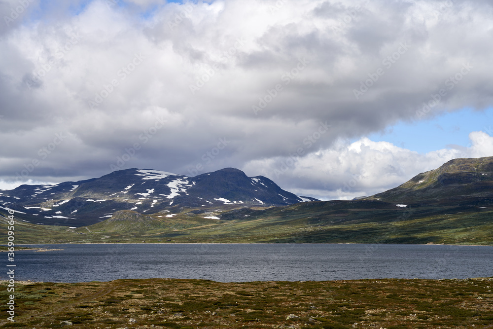 Snow covered mountains and a lake during summertime on a highland in Norway, close to Hemsedal