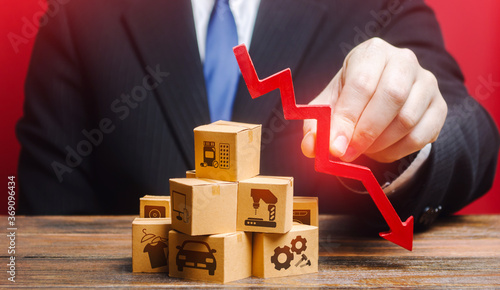 Fotografie Businessman holds a red down arrow over the boxes