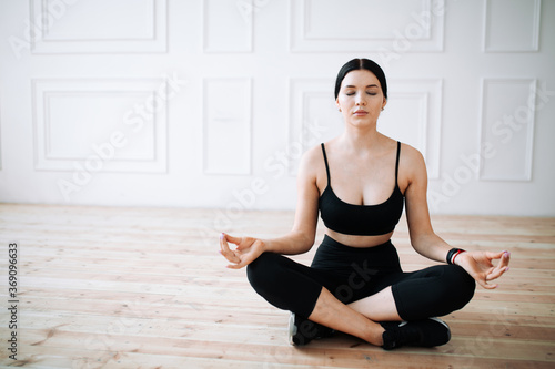 Beautiful Korean woman sitting in the lotus position. Performs yoga asanas and meditates