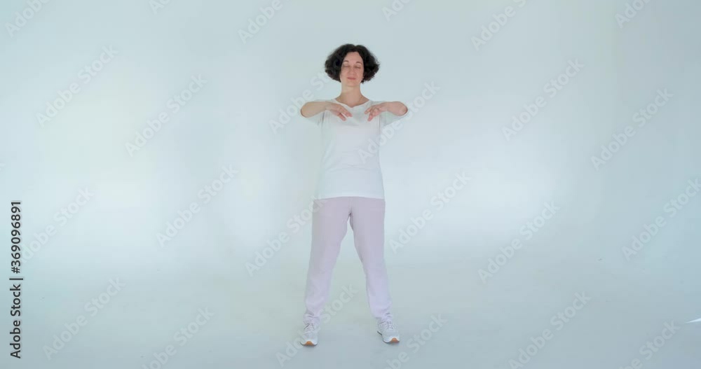 woman practicing qi qong at white studio traditional chinese gymnastics woman practicing qi qong at white studio traditional chinese gymnastics