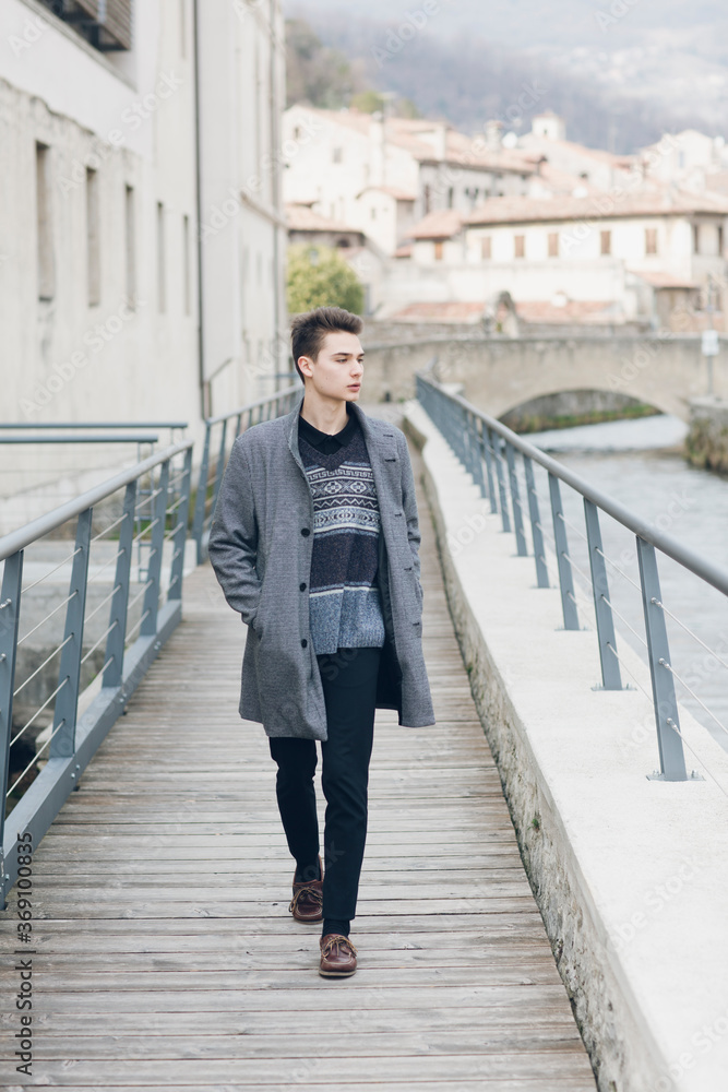 Trendy young male walking on bridge Trendy young male walking on bridge