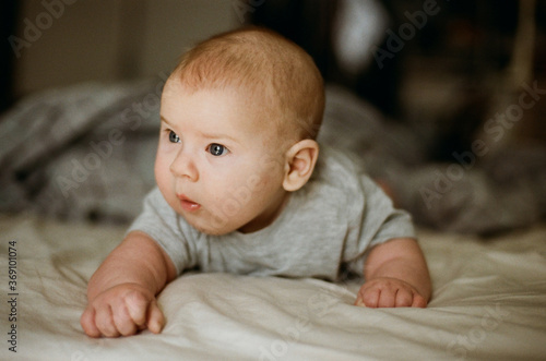 Three month baby lying on a bed photo