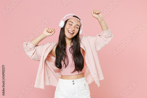 Fotografie Funny young asian woman girl in casual clothes cap posing isolated on pastel pink background studio portrait
