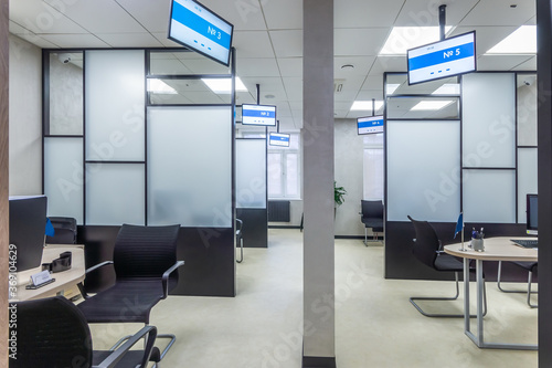 The modern cubicle office with glass panels, office furniture and digital displays. Sales office interior