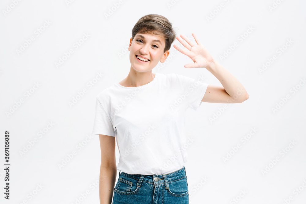 Hello how are you. Cheerful positive good-looking girl student in striped t-shirt raise hand and waving friendly. Hello how are you. Cheerful positive good-looking girl student in striped t-shirt raise hand and waving friendly.