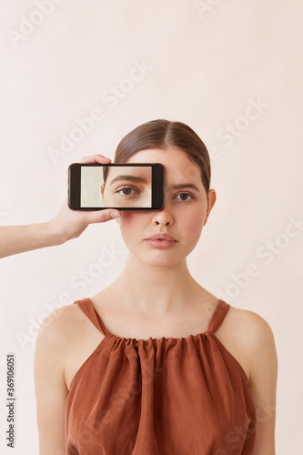 Young Model With Her Eye On Smartphone Screen photo
