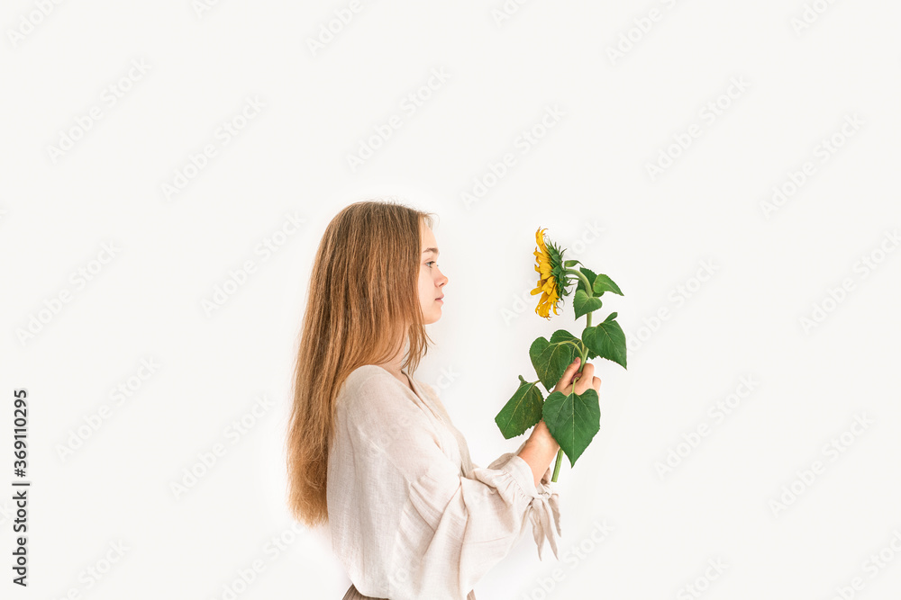 Beautiful young woman in linen dress holding sunflower on white background. Autumn concept. Beautiful young woman in linen dress holding sunflower on white background. Autumn concept.