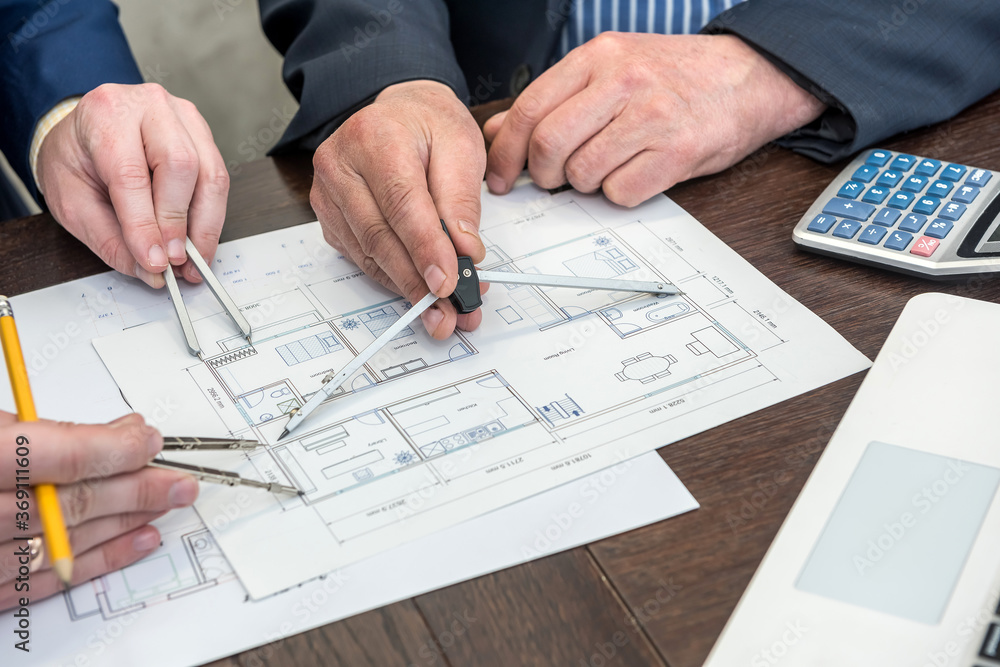 Two busimessman working with house architectural plan at office desk Two busimessman working with house architectural plan at office desk