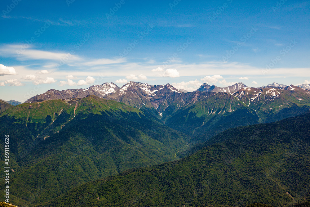 Fototapeta premium Beautiful panoramic view of high snow-capped mountains on a clear sunny day.