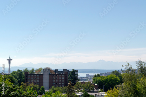 Panoramic view of the Olympic Mountain Range across from Seattle and partial view of a Seattle neighborhood with Space Needle on the left.