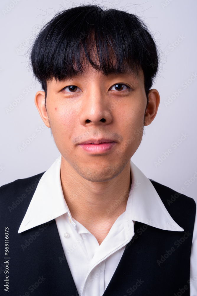 Portrait of young handsome Asian businessman against white background Portrait of young handsome Asian businessman against white background