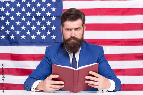 Book for mastering american english. Bearded man read book on USA flag background. Reading book. Vocabulary and grammar. Knowledge and information. Library and bibliotheca. Teachers book photo