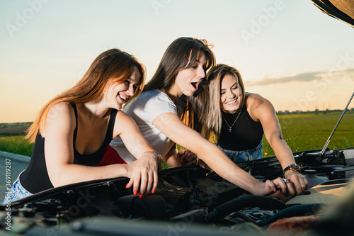 Three young women got trouble during road trip out of city, open bonnet to check breaking details and try to calm down