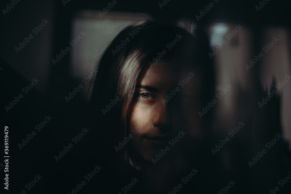 Dramatic portrait of young woman looking at camera with a serious face