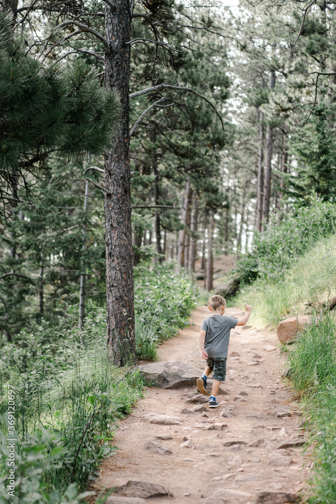 Little boy hiking up mountain trail Little boy hiking up mountain trail