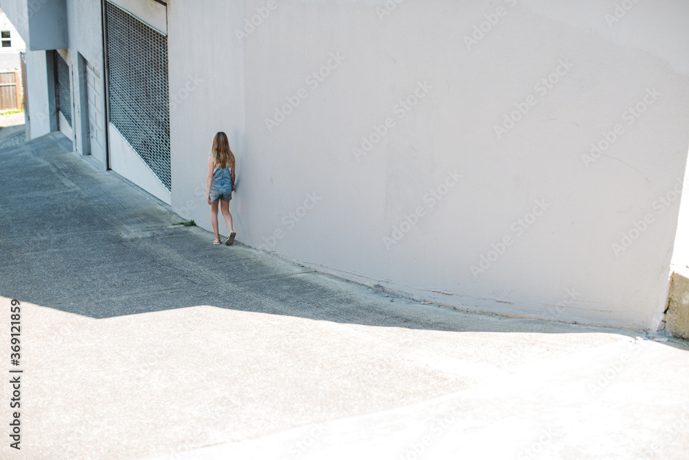 Lonely looking girl walking in shadow. Lonely looking girl walking in shadow.