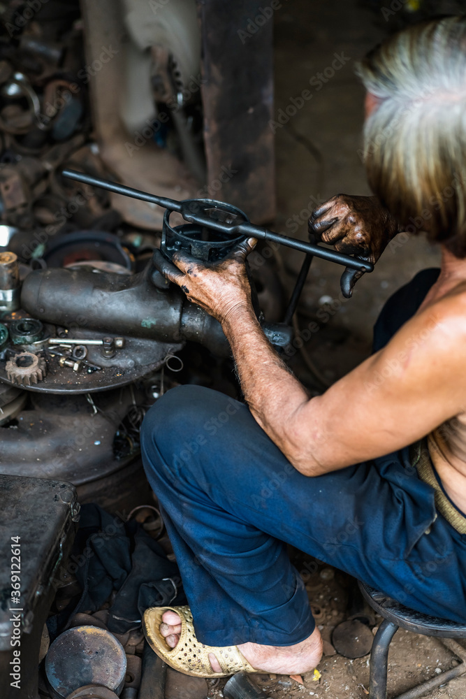 Man working in a mechanical workshop in Vietnam Man working in a mechanical workshop in Vietnam
