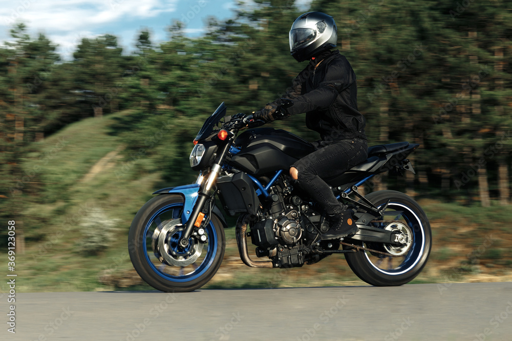 Motion photo of biker driving motorcycle in sunset on the country road. Motion photo of biker driving motorcycle in sunset on the country road.