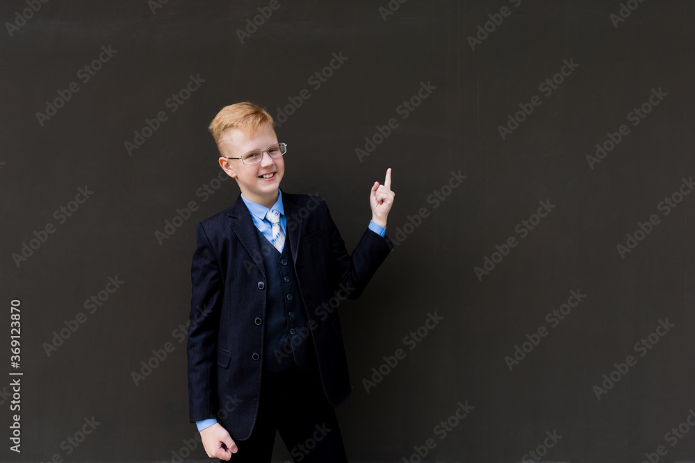 Boy in tuxedo points to the side Boy in tuxedo points to the side