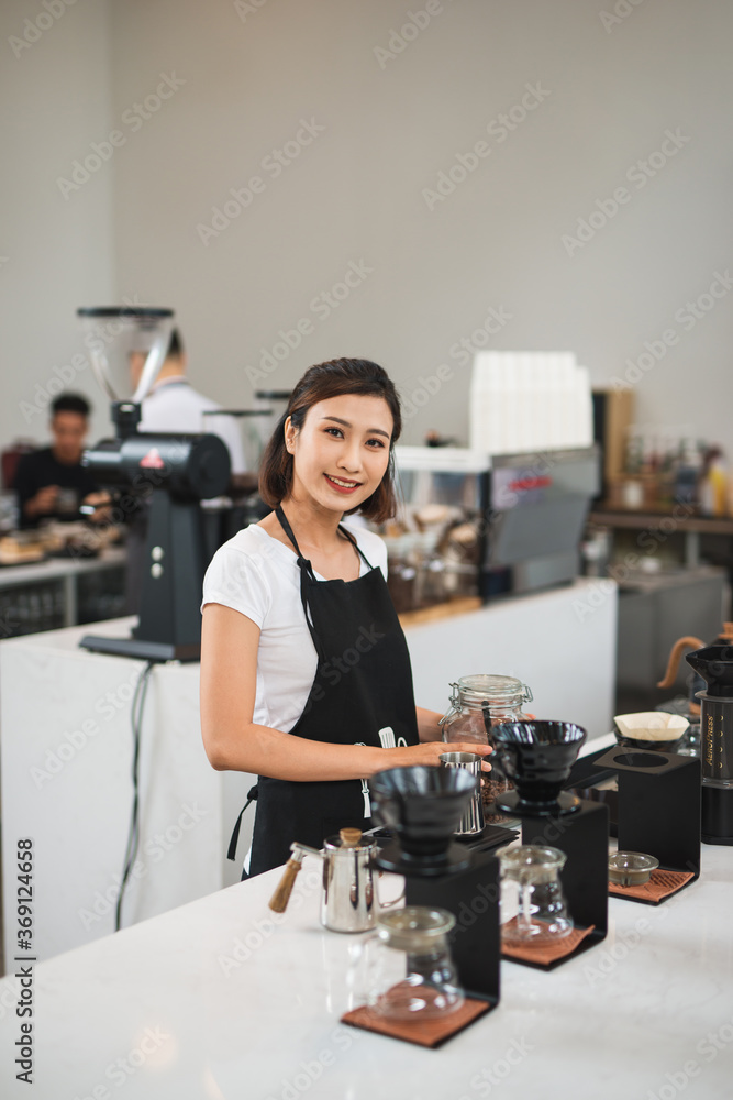 Happy young female barista brewing coffee Happy young female barista brewing coffee