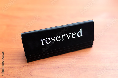 Reserved table. Black white tag placed on a wooden table