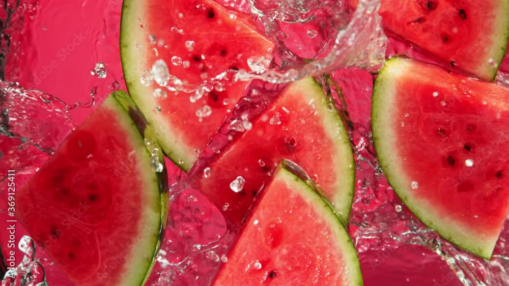Super Slow Motion Shot of Falling Fresh Watermelon Slices into Water on Red Background at 1000fps. Super Slow Motion Shot of Falling Fresh Watermelon Slices into Water on Red Background at 1000fps.