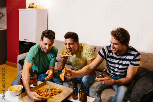 Friends watching a soccer match at home photo