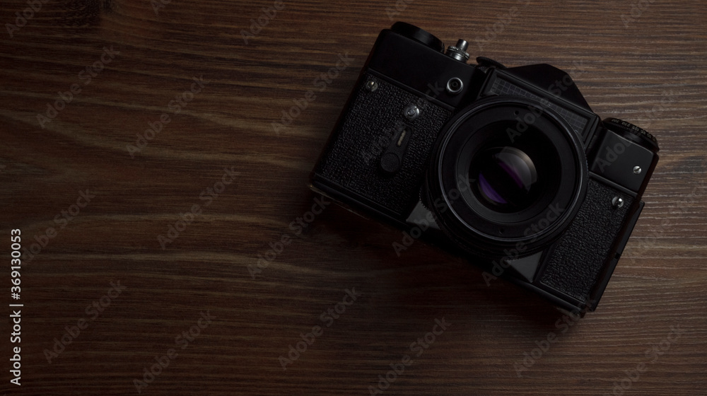 black vintage camera on wooden surface