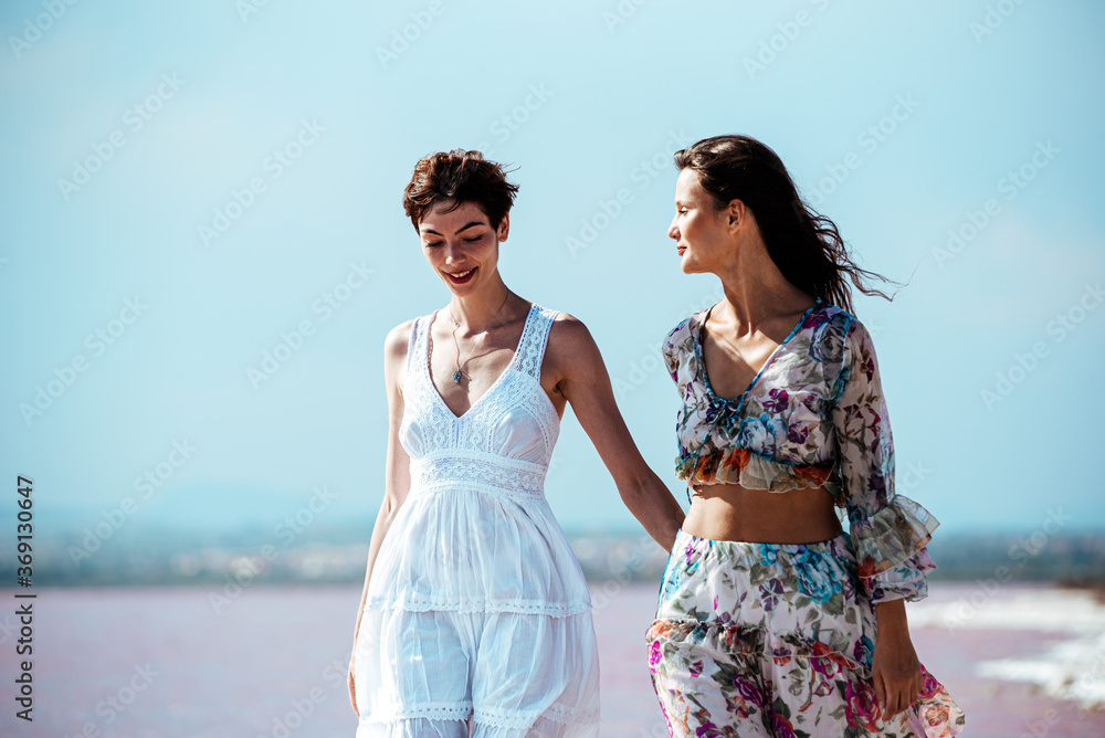 cute Women walking on a amazing pink lake holding hands