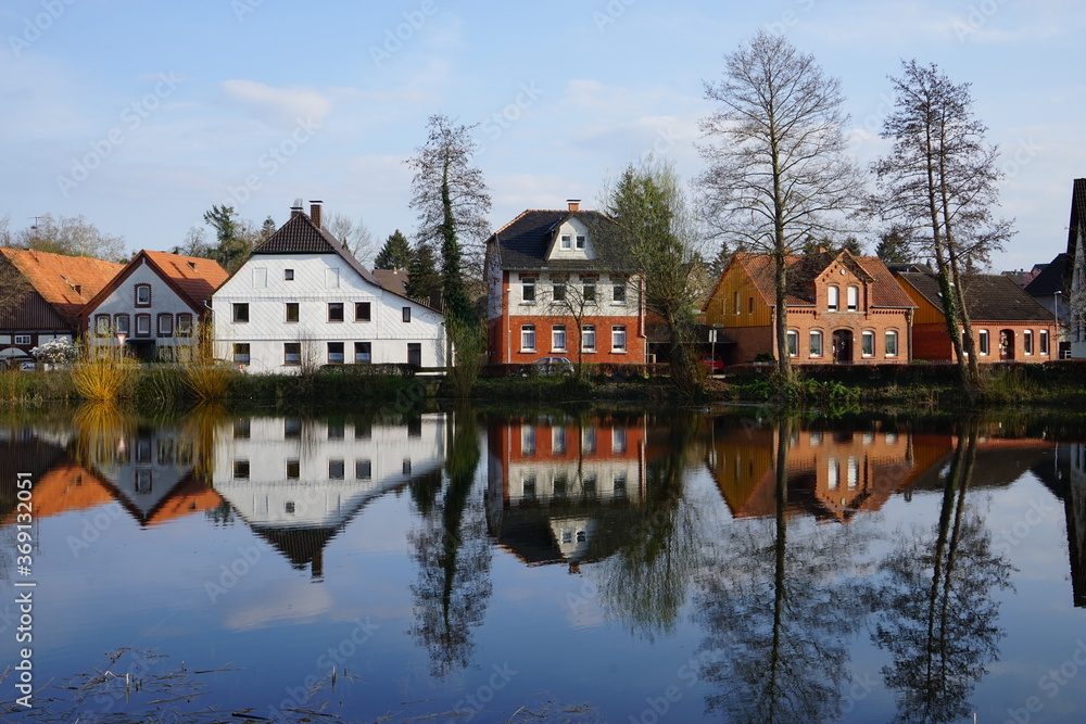 Spiegelung eines See mit Häusern in einem Ort Spiegelung eines See mit Häusern in einem Ort