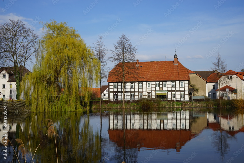 Spiegelung eines See mit Häusern in einem Ort Spiegelung eines See mit Häusern in einem Ort