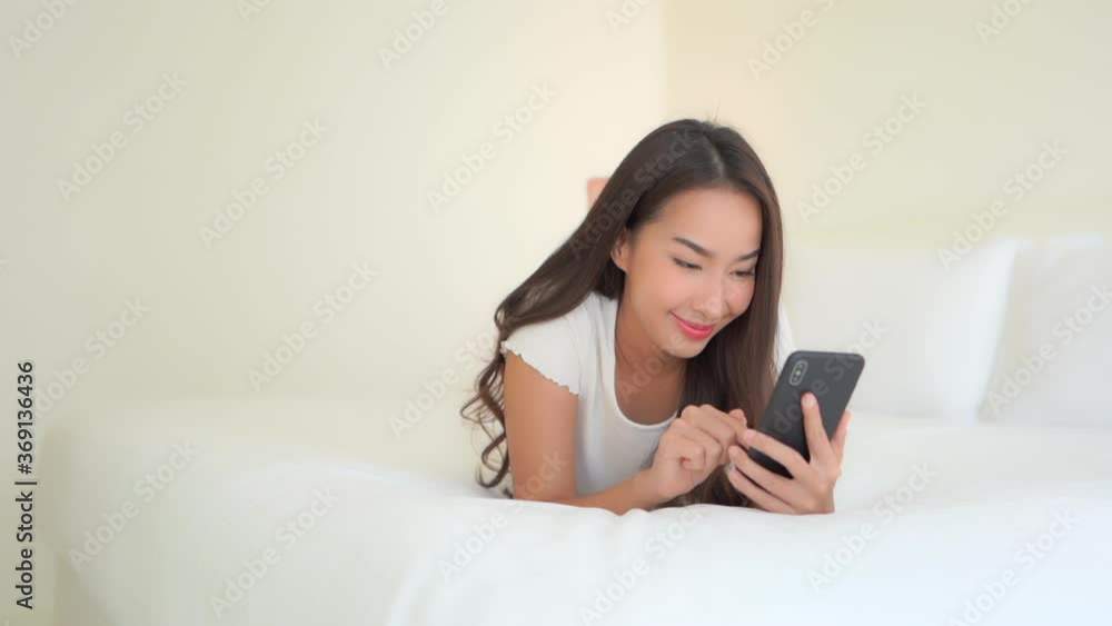 An attractive young woman keeps connected with family and friends even while enjoying the comfort of her exclusive resort hotel room. An attractive young woman keeps connected with family and friends even while enjoying the comfort of her exclusive resort hotel room.