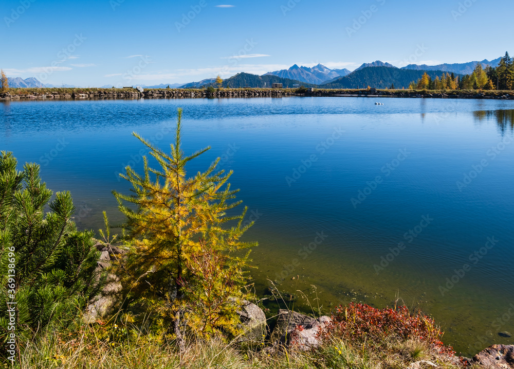 Peaceful autumn Alps mountain lake with clear transparent water and reflections. Reiteralm, Steiermark, Austria.