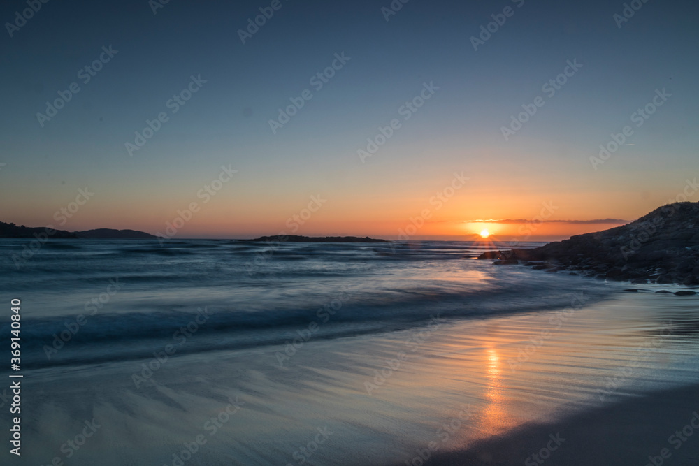 Warm, calm and beautiful sunset on the virgin beach of Barra, Ponteceso. The waves move smoothly