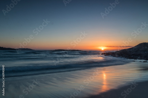 Warm  calm and beautiful sunset on the virgin beach of Barra  Ponteceso. The waves move smoothly