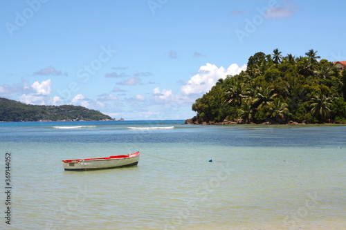 Colorful boat in turquoise blue water sea with green vegetation on a paradisiac Seychelles island.  Seychelles. La Digue, Mahe, Praslin. © Sabrina