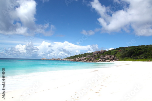 Paradise panorama of an Seychelles island beach with turquoise blue water sea, white sand beach and granit rocks with green vegetation, Seychelles. La Digue, Mahe, Praslin.