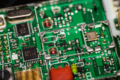 Fotografie A microcircuit with transistors, resistors, capacitors, coils, contacts on an electronic board in an enlarged form