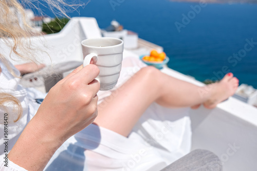 woman hand holding coffee cup on terrace bacony of house or hotel Sea View photo