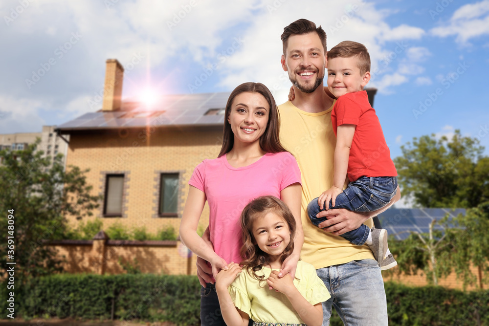Happy family near their house with solar panels. Alternative energy source Happy family near their house with solar panels. Alternative energy source