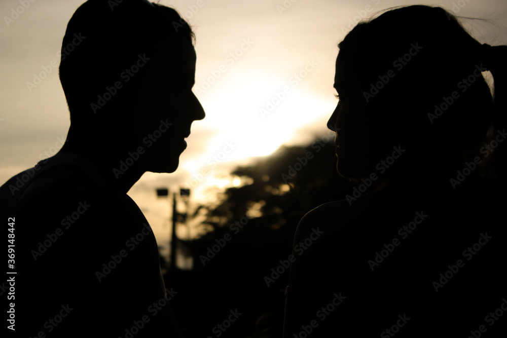 Silhouettes of people, with the sun in the background.